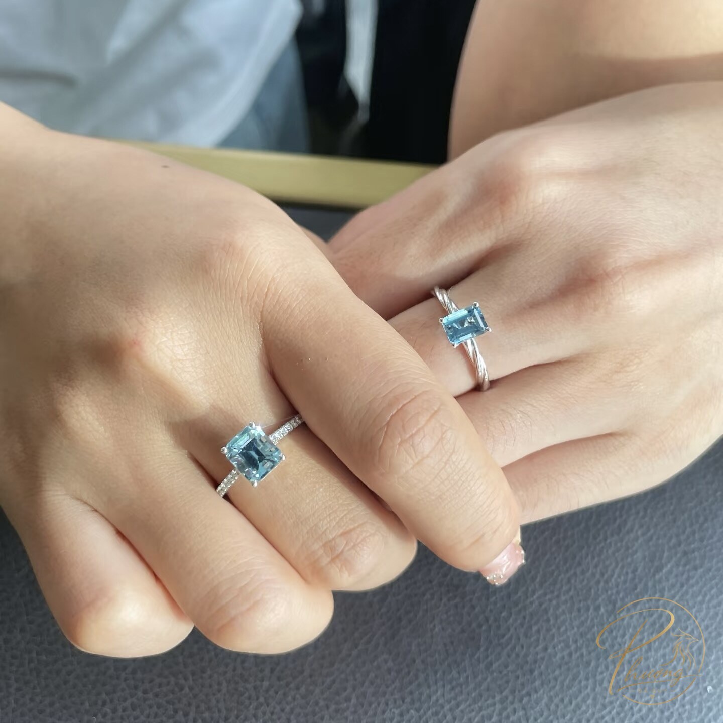 hai bàn tay đeo nhẫn aquamarine tự nhiên cắt vuông