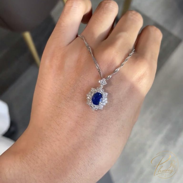 mặt dây chuyền sapphire lam tự nhiên giác cắt facet ổ kim cương halo đeo trên tay