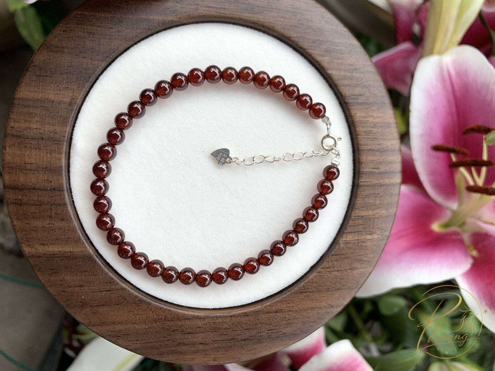 vòng tay đá Garnet đỏ rượu vang dạng cabochon 5mm đặt trên khay gỗ