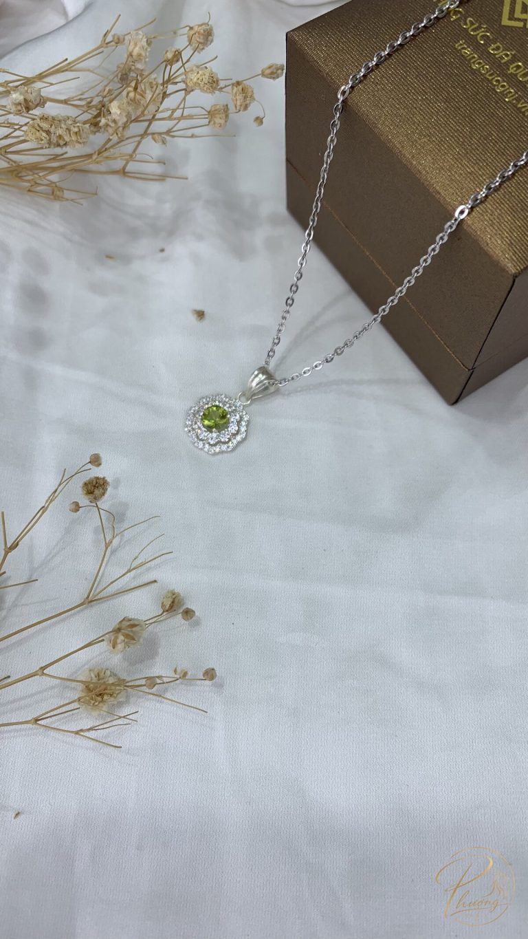 Peridot là gì - mặt dây chuyền bạc đính đá Peridot lục ánh vàng đặt cạnh hộp quà và hoa khô