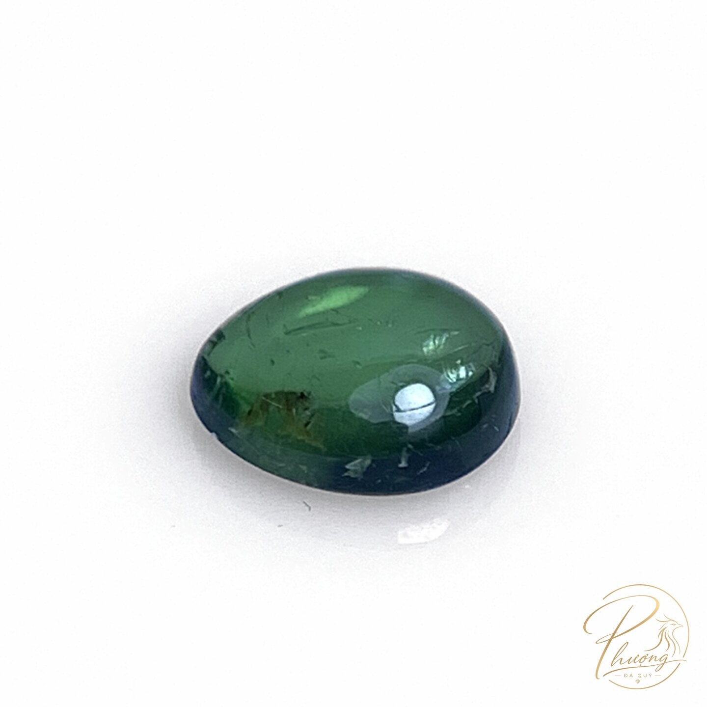 Tourmaline xanh lục mài cabochon oval trên nền trắng