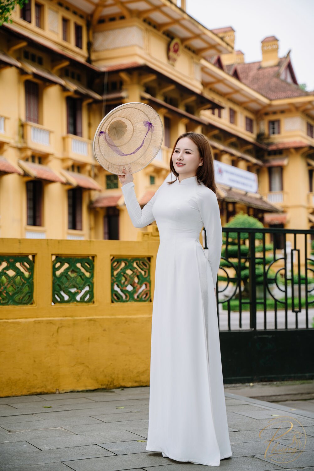 Chân dung Phượng Đá Quý mặc áo dài trắng, cầm nón lá