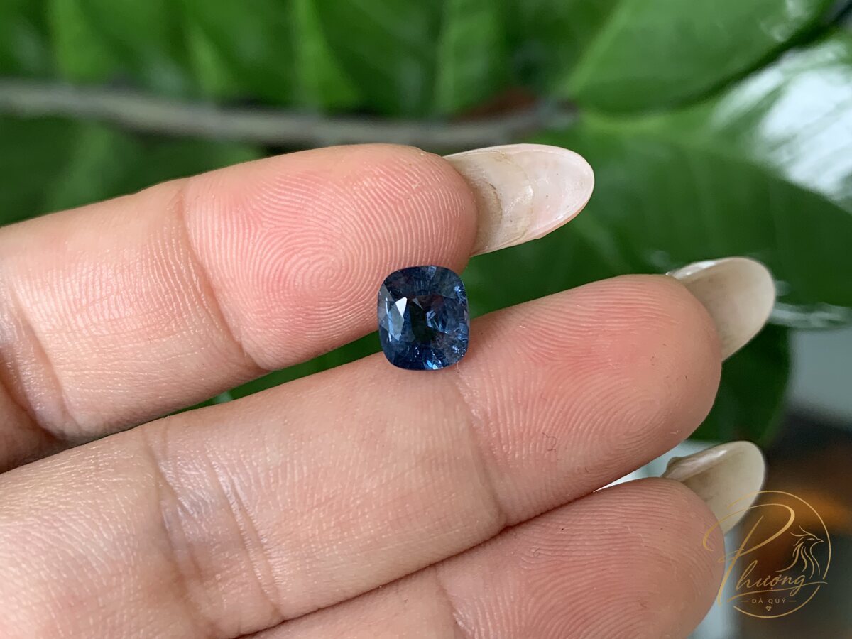 Viên Spinel xanh ngan tự nhiên mài cushion cầm giữa hai ngón tay